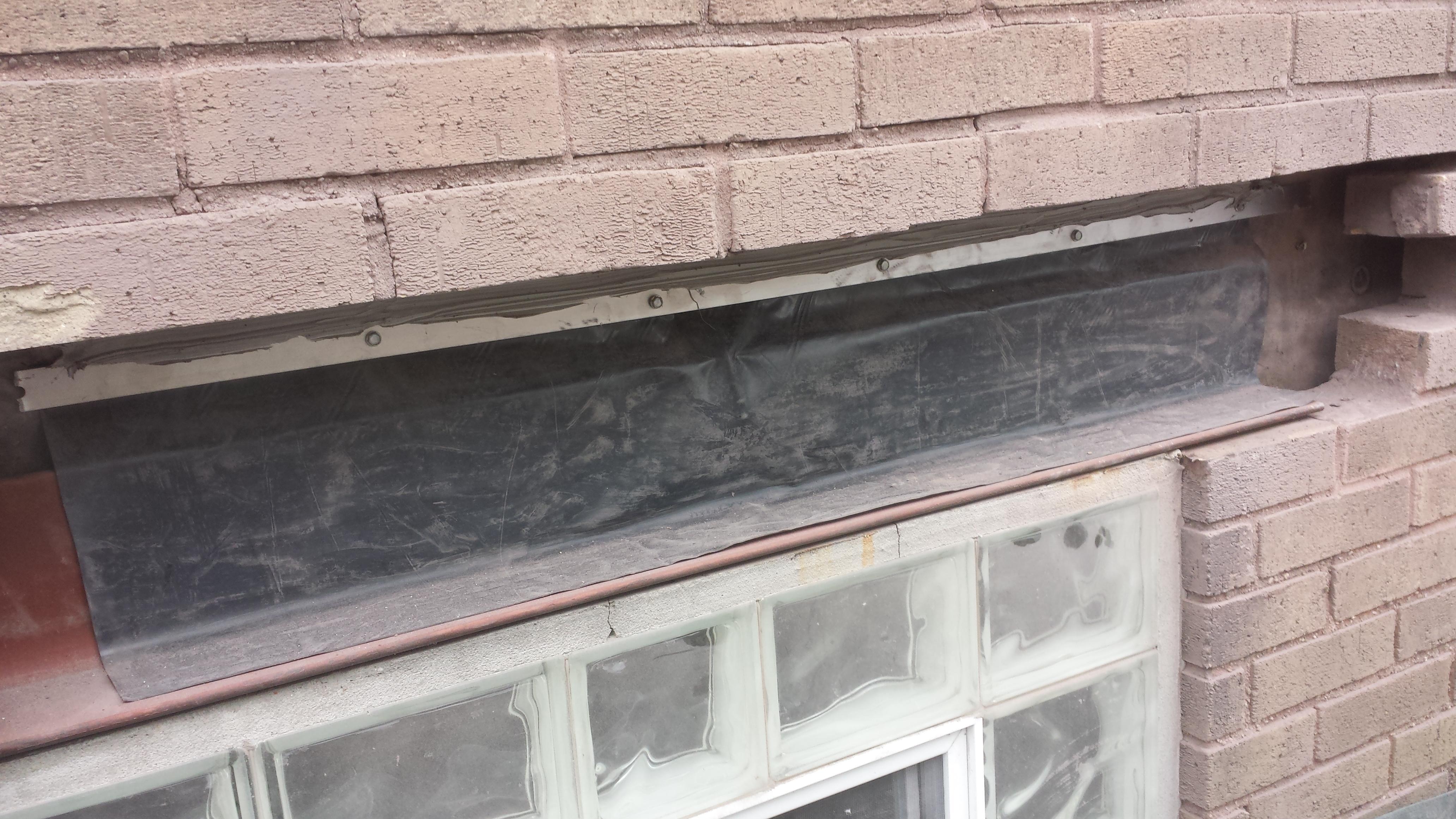 This is a picture of a new lintel with flashing membrane that has been fastened to the wall at the top, and sealed so no water can get behind.