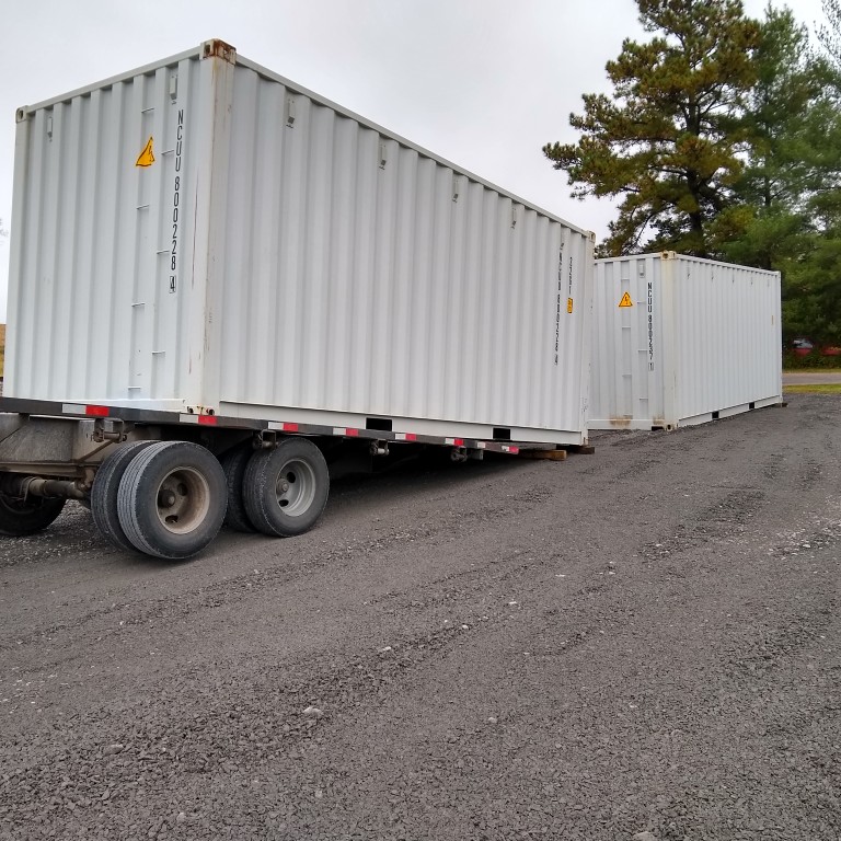 Two one trip 8x20' commercial containers being delivered to our facility today. Our special delivery system lifts then rolls them into place on your property.