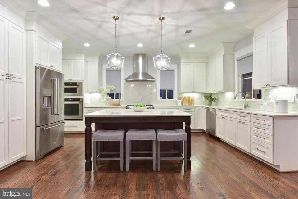 No modern kitchen is complete without the right window treatments. These Gray Roller Shades by Budget Blinds of Arlington & Alexandria are the perfect finishing touch for this ultra-modern white kitchen.