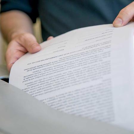 Close up of document being placed in shredding bin