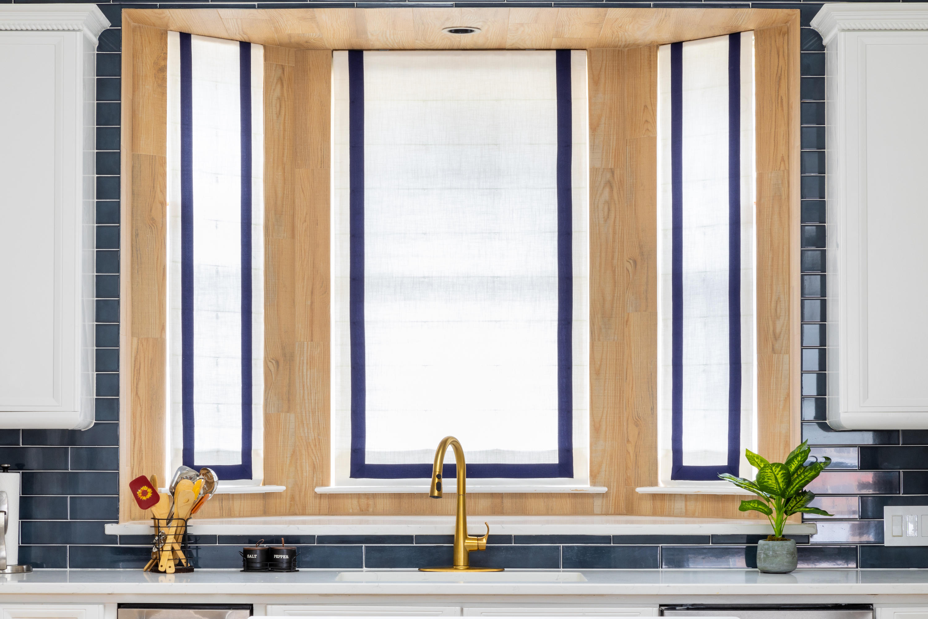 These white and blue roman shades elevate the feel of this costal kitchen! By incorporating pops of color in your shades, you can create a cohesive look with the rest of your space and draw the eyes of guests toward your beautiful decor.