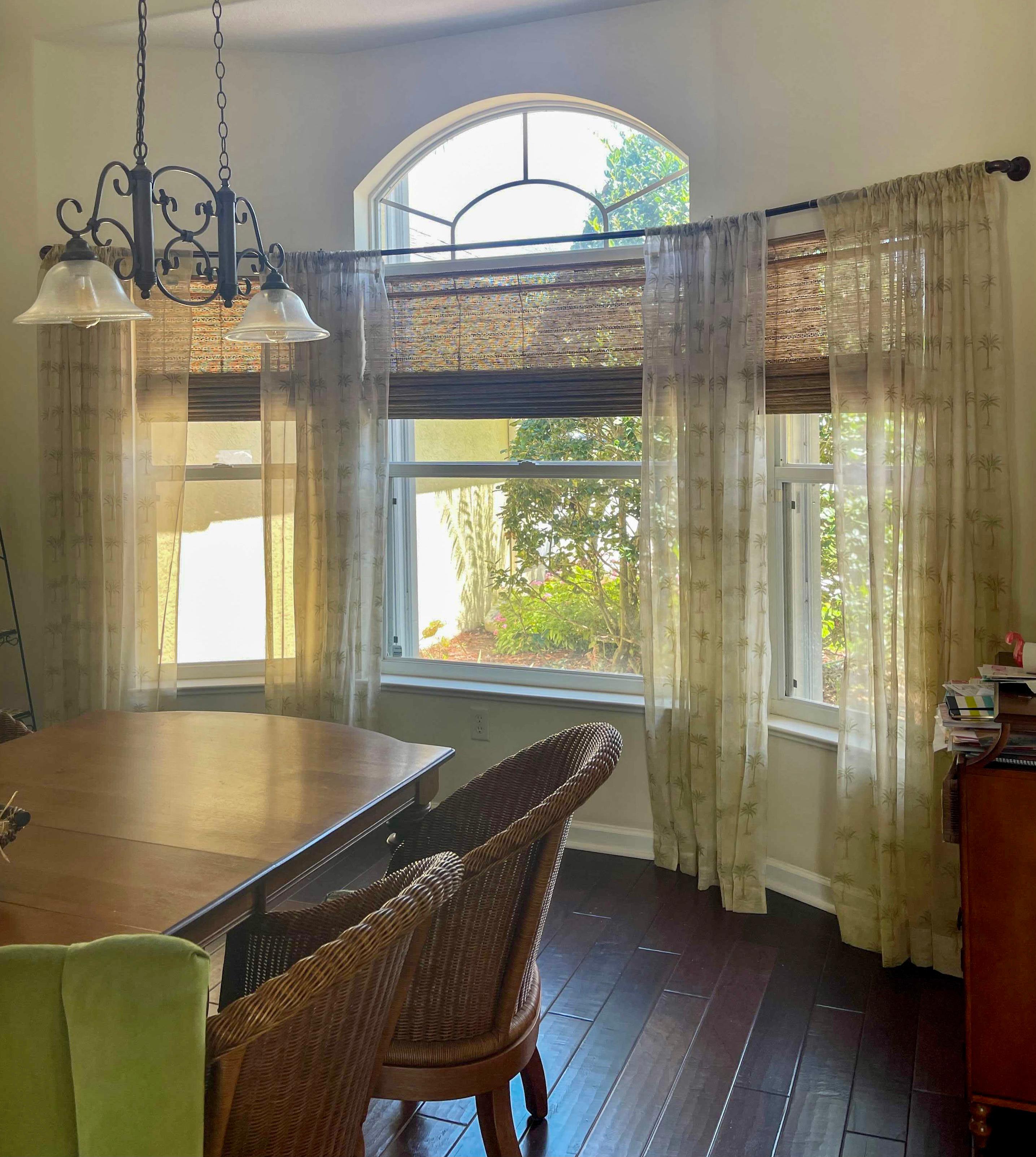 Woven wood shades and sheer patterned drapery create a natural boho feel to match this Vero Beach home's decor.