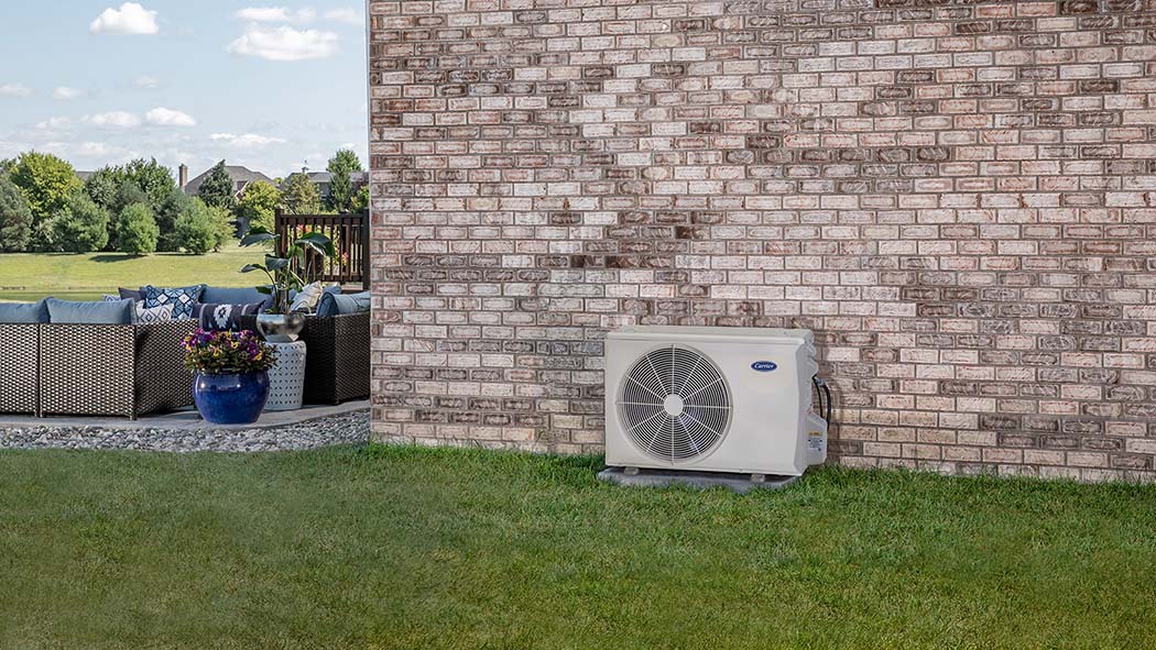 A ductless mini split installation outside of a brick home