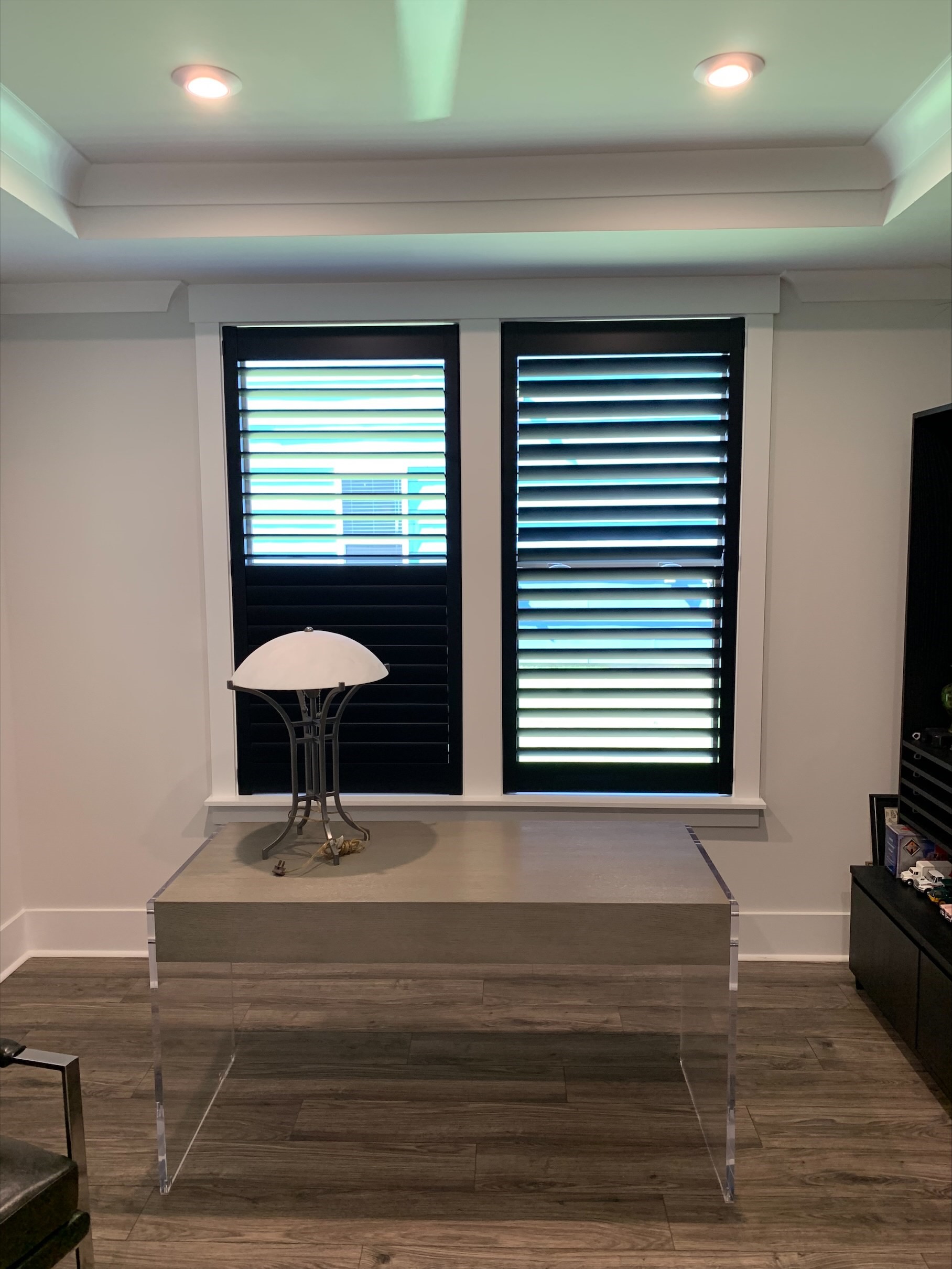 Shutters can be a great accent piece inside the home! These dark shutters really give a pop of life to the window in this home office!