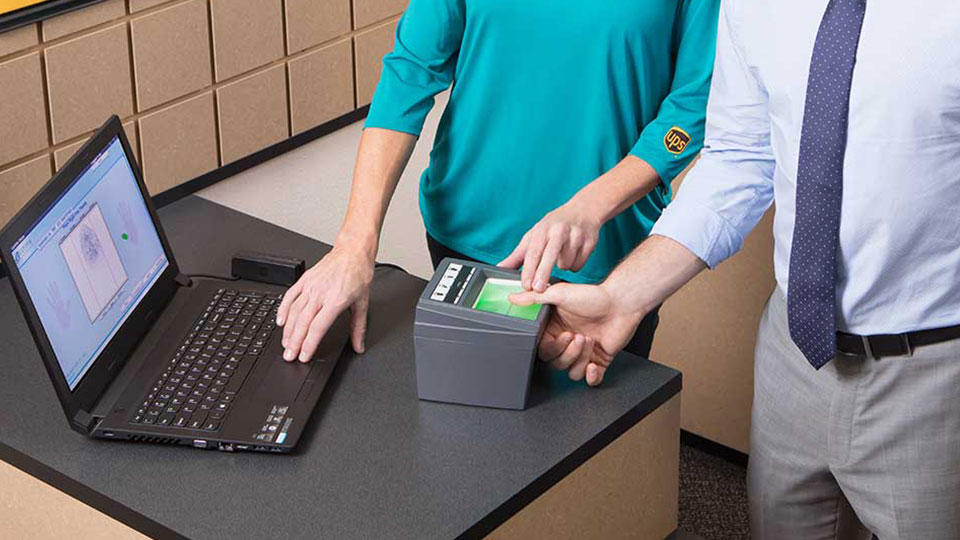 man being fingerprinted using Live Scan