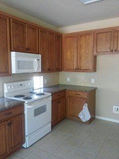 Kitchen microwave and cabinet before custom vent hood installation.