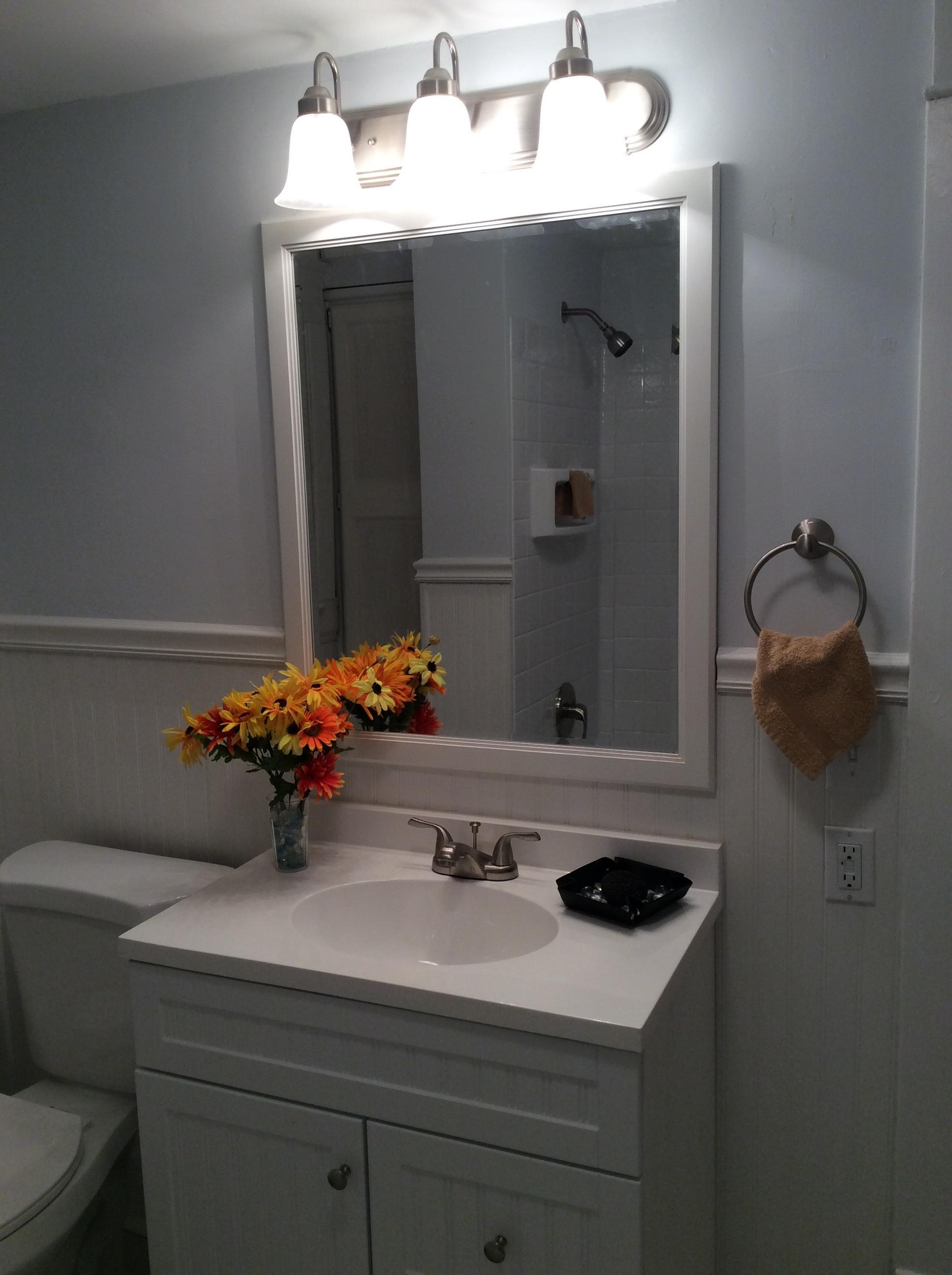 Dream bathroom with bead board walls, new tub surround, new floor, stylish vanity and brushed nickel hardware.
