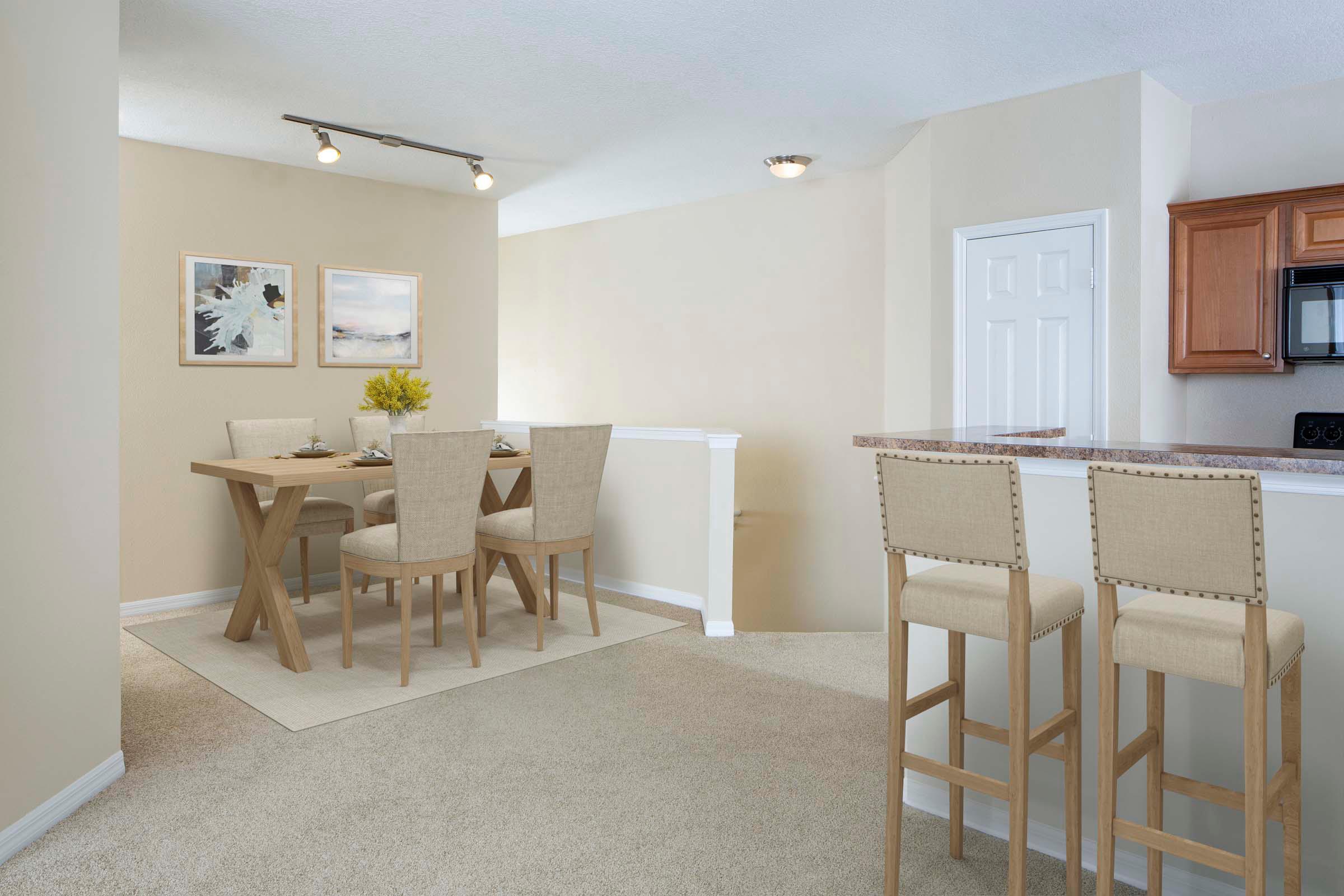 Dining room alongside kitchen with track lighting and carpet flooring