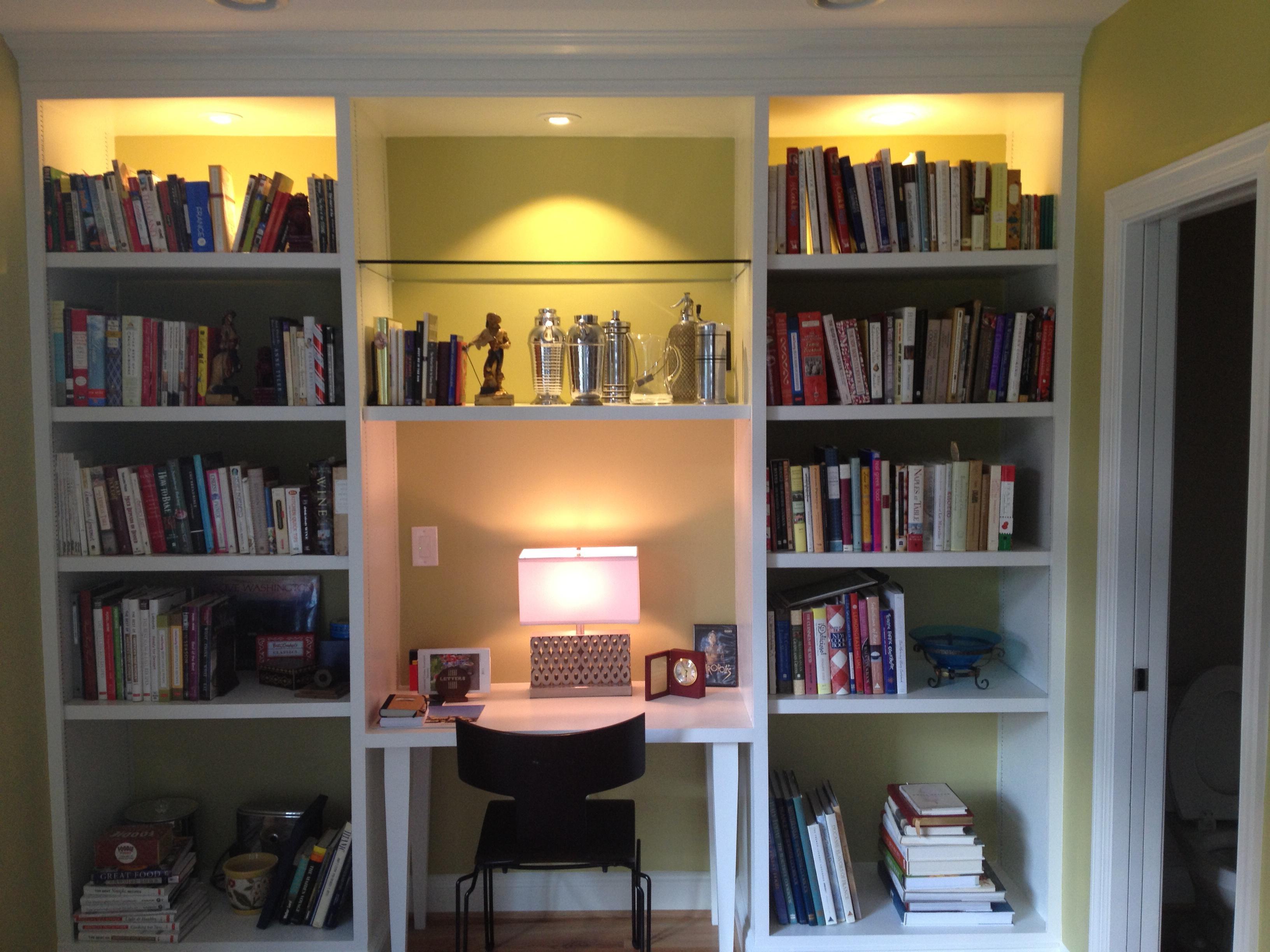 Custom built desk with, custom lighting, glass shelf, and a layout that works for both books and displaying items