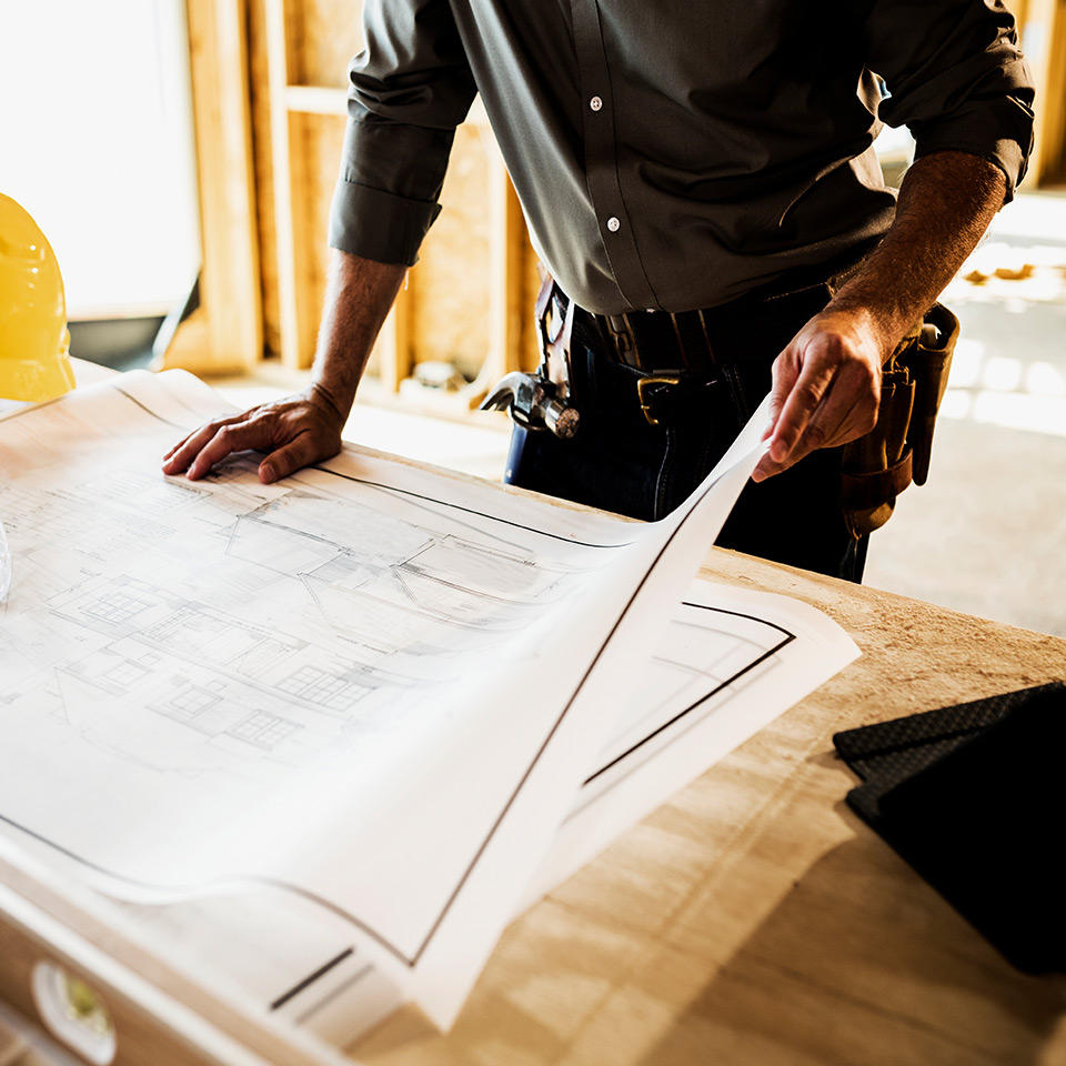 large format printed drawings on a desk.