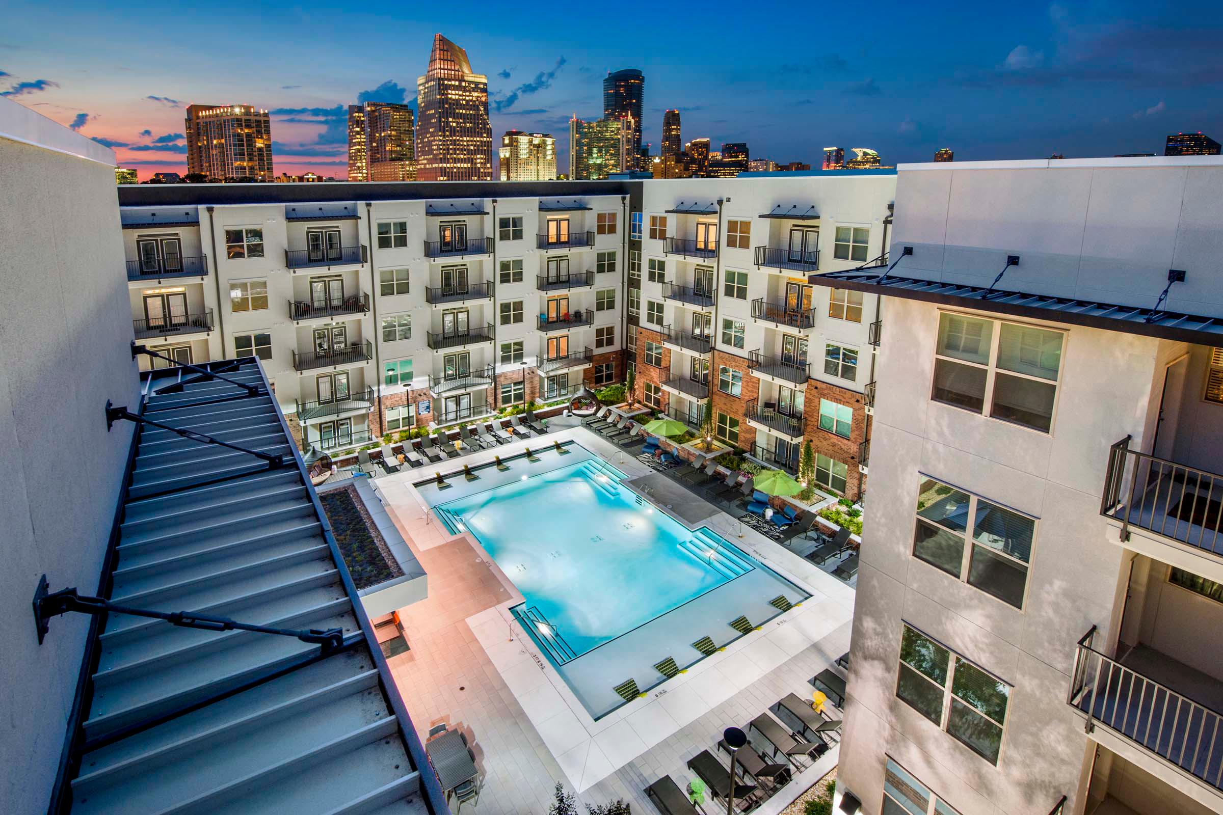 Pool at night with city skyline views