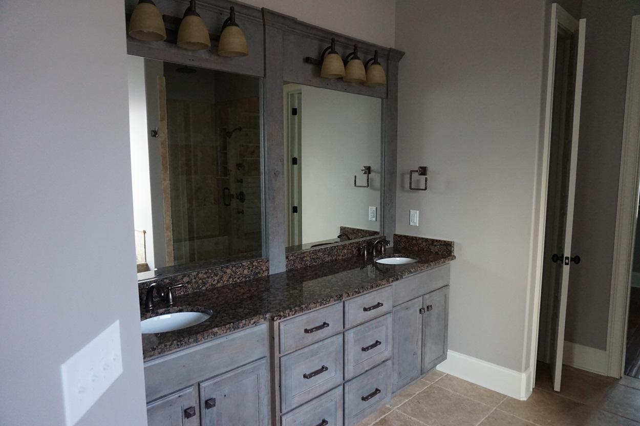 Rather than a long run of vanity cabinets we simply bumped the drawer basin forward to offer a different dimension.  We incorporated the lights and mirrors into a custom frame material as well that appears to be a complete wall design.