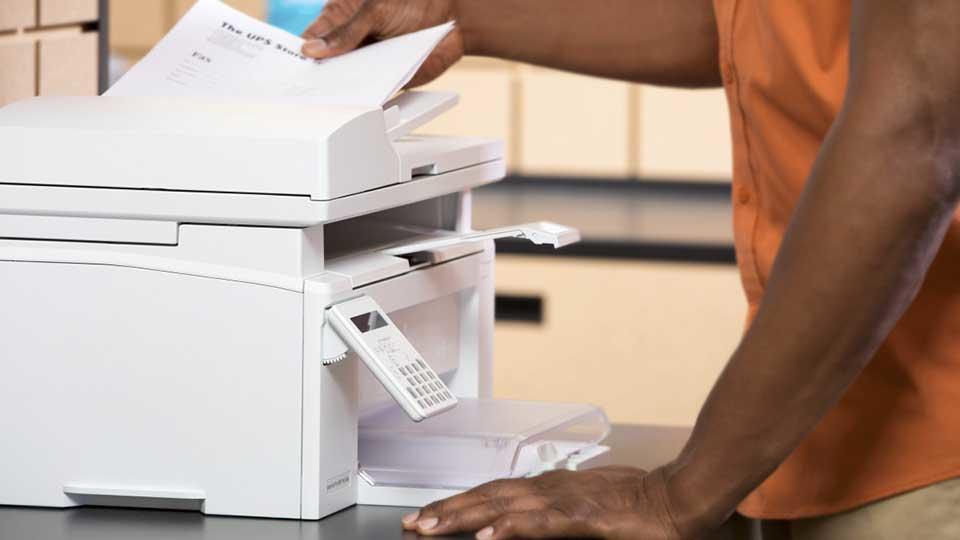 Close up photo of employee faxing documents