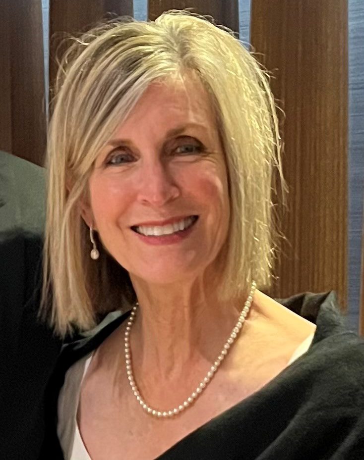 A portrait of a caucasian woman with shoulder-length blonde hair