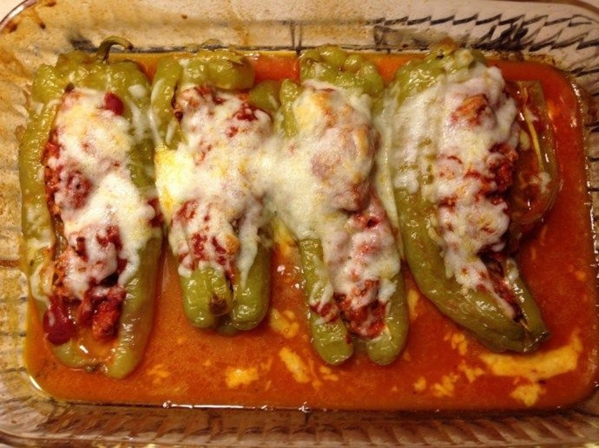 SAUSAGE STUFFED HUNGARIAN PEPPERS ladled with our delicious marinara and baked with mozzarella on...