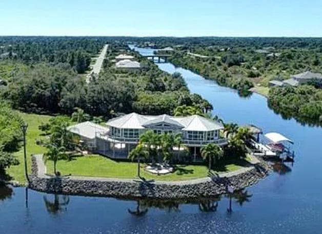 Perched high and dry overlooking the convergence of two canals into the Gulf of Mexico in south Florida, this elevated double pedestal home is safe from storm surge and flooding