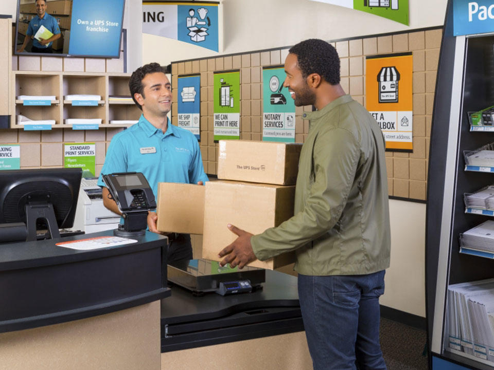 man at counter with packages to ship