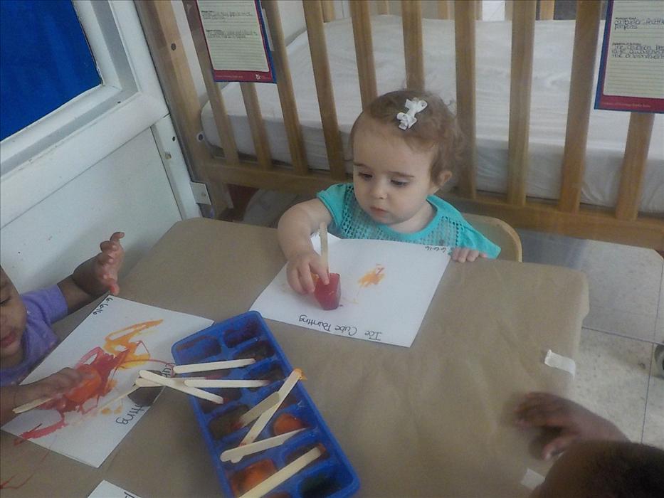 Infants painting with popsicles