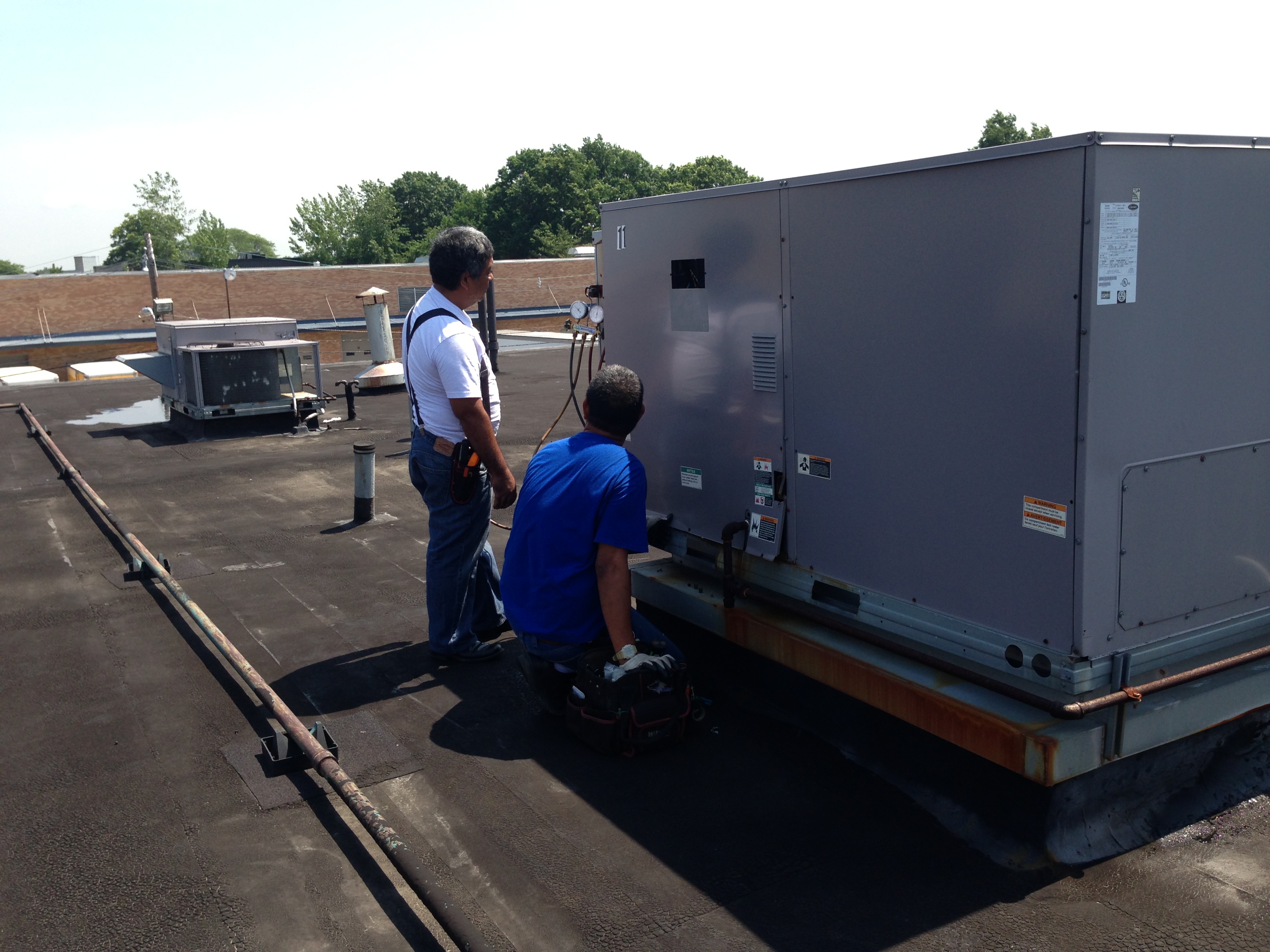 Technicians at work on rooftop unit