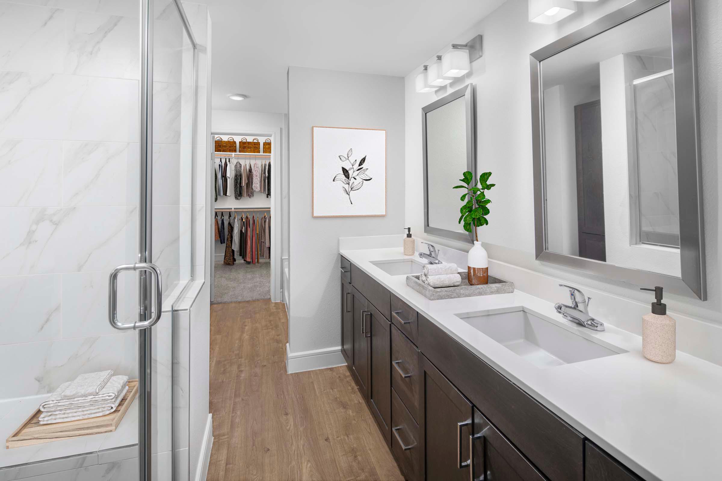 Villas townhome bathroom with walk-in shower, brown cabinets and two sinks at Camden Greenville