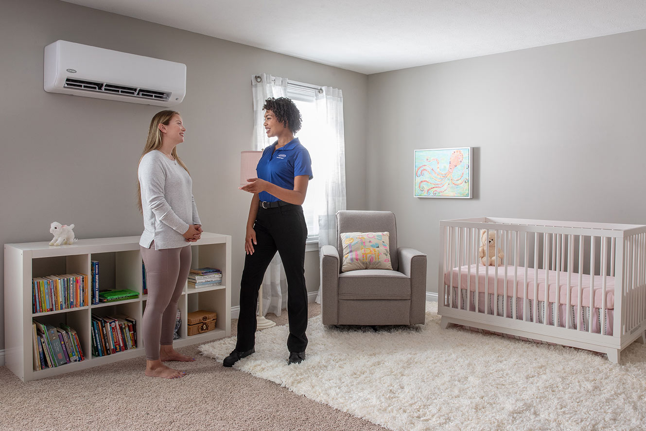 A Carrier dealer talks with a woman after a ductless mini split installation