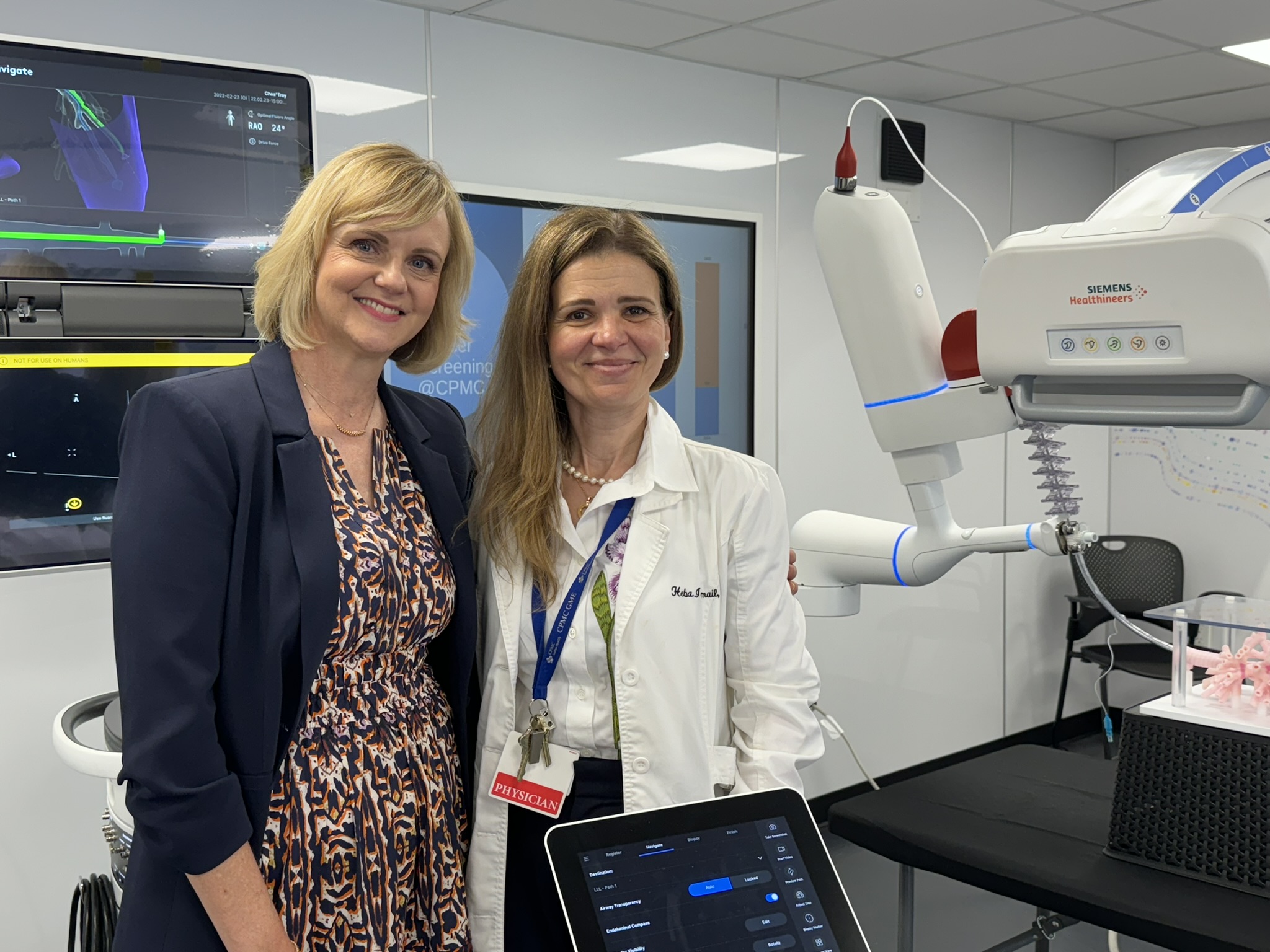 A patient and her doctor stand in front of new lung cancer diagnostic technology