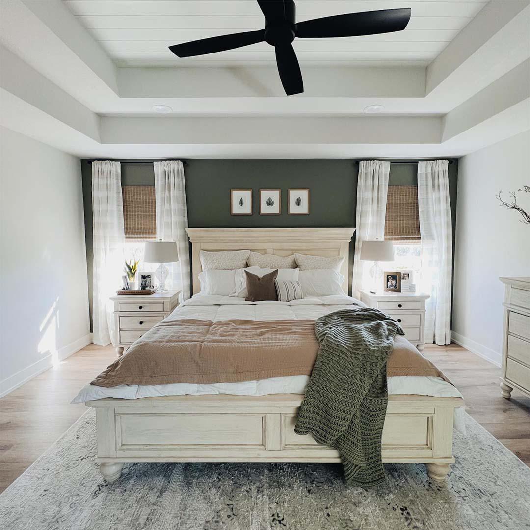 This customer worked with Budget Blinds to design a bedroom that felt true to their style and taste, pairing woven wood shades with sheer drapery for a layered look. (Photo by Budget Blinds of Columbia)
