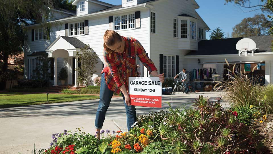 A homeseller plants an H-frame yard sign in their driveway planter that says "Open House Today"