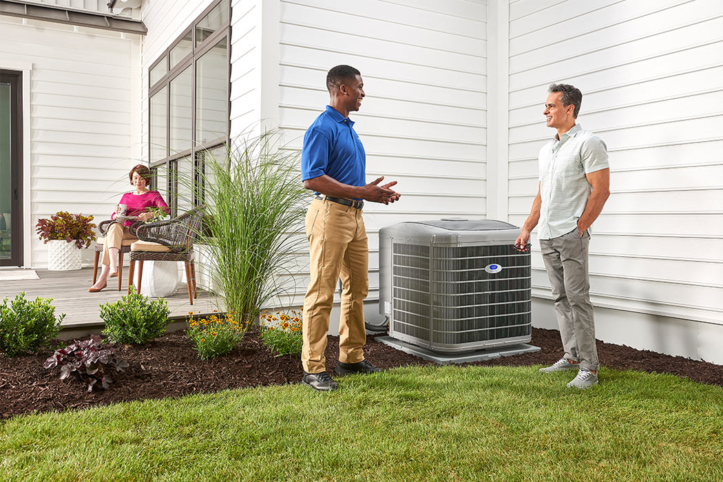 A Carrier dealer discusses air conditioner repair and service with a homeowner