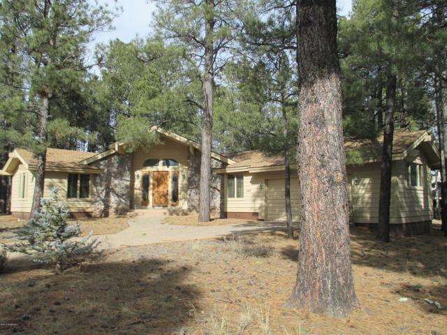 This Fabulous Bright & Sunny home nestled in the pines offers an open concept great room with beautiful wood floors, granite counter tops throughout, tongue & groove ceilings, exposed wood beams, a rock enclosed wood fireplace and panoramic views through the large array of windows. The kitchen offers a nice sized butcher block Island with a cook top and an eat-in bar.  