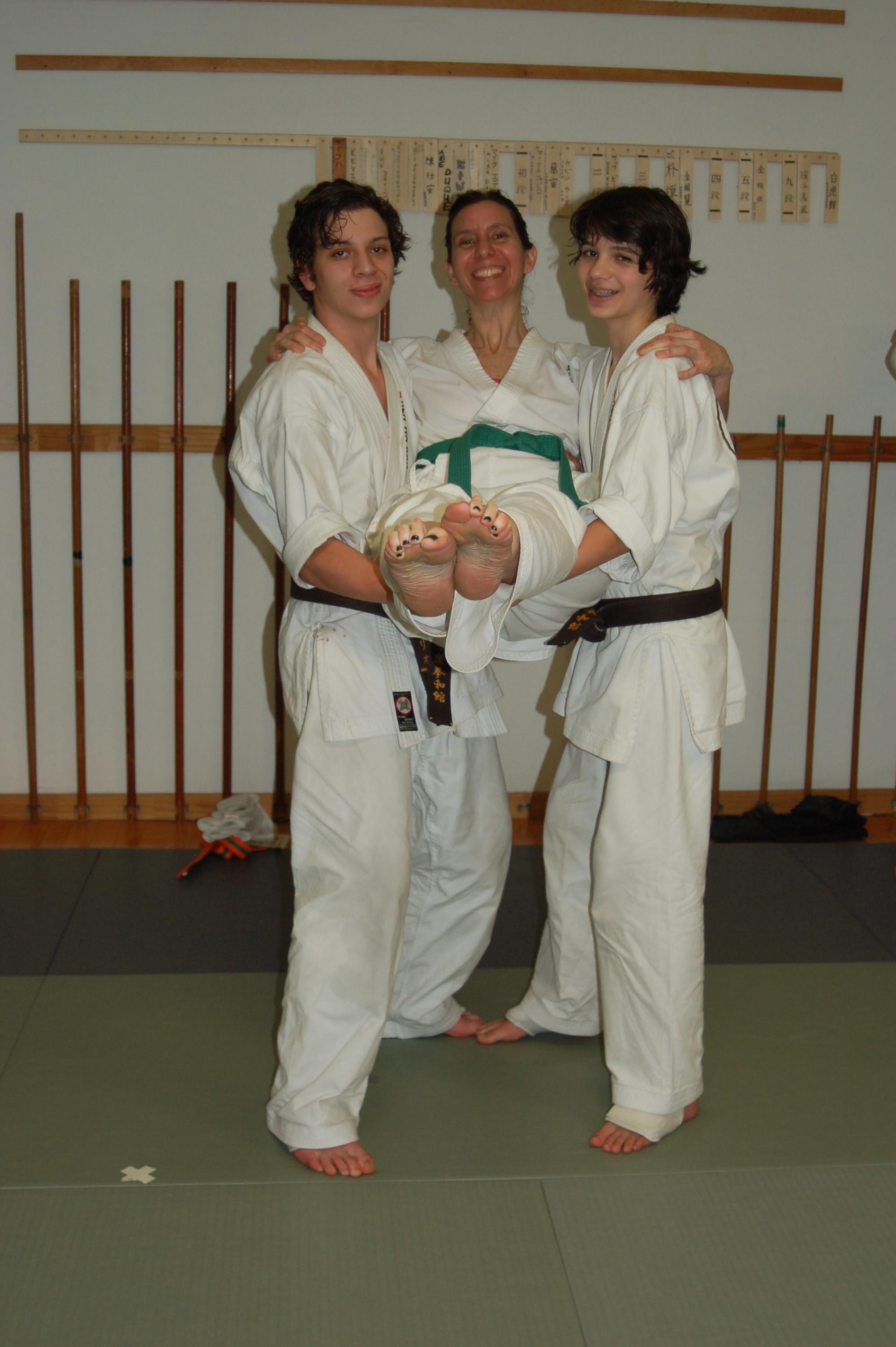 Two young black belts carry their mother in celebration of her promotion to green belt! Mom's catching up! 