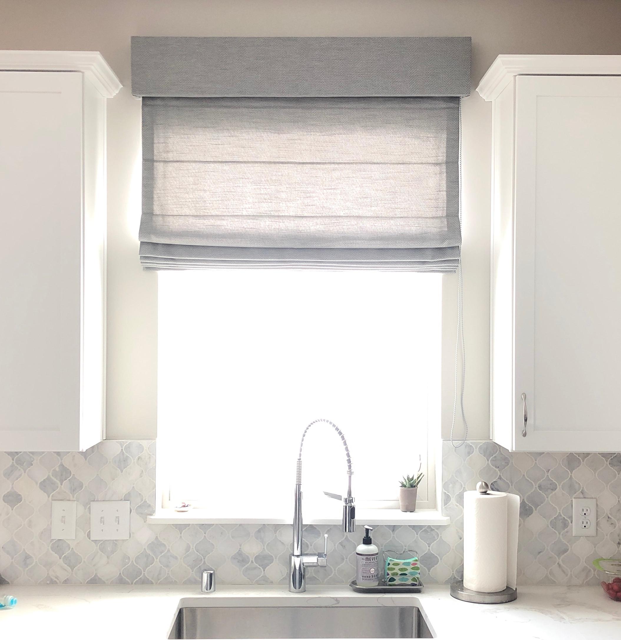 We installed a Roman shade above the kitchen sink in this Victoria home, to add a touch of softness in an area surrounded by hard-edged surfaces.