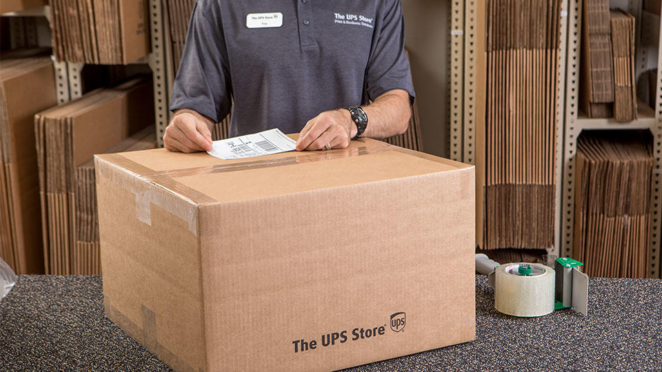 Employee placing shipping label on box