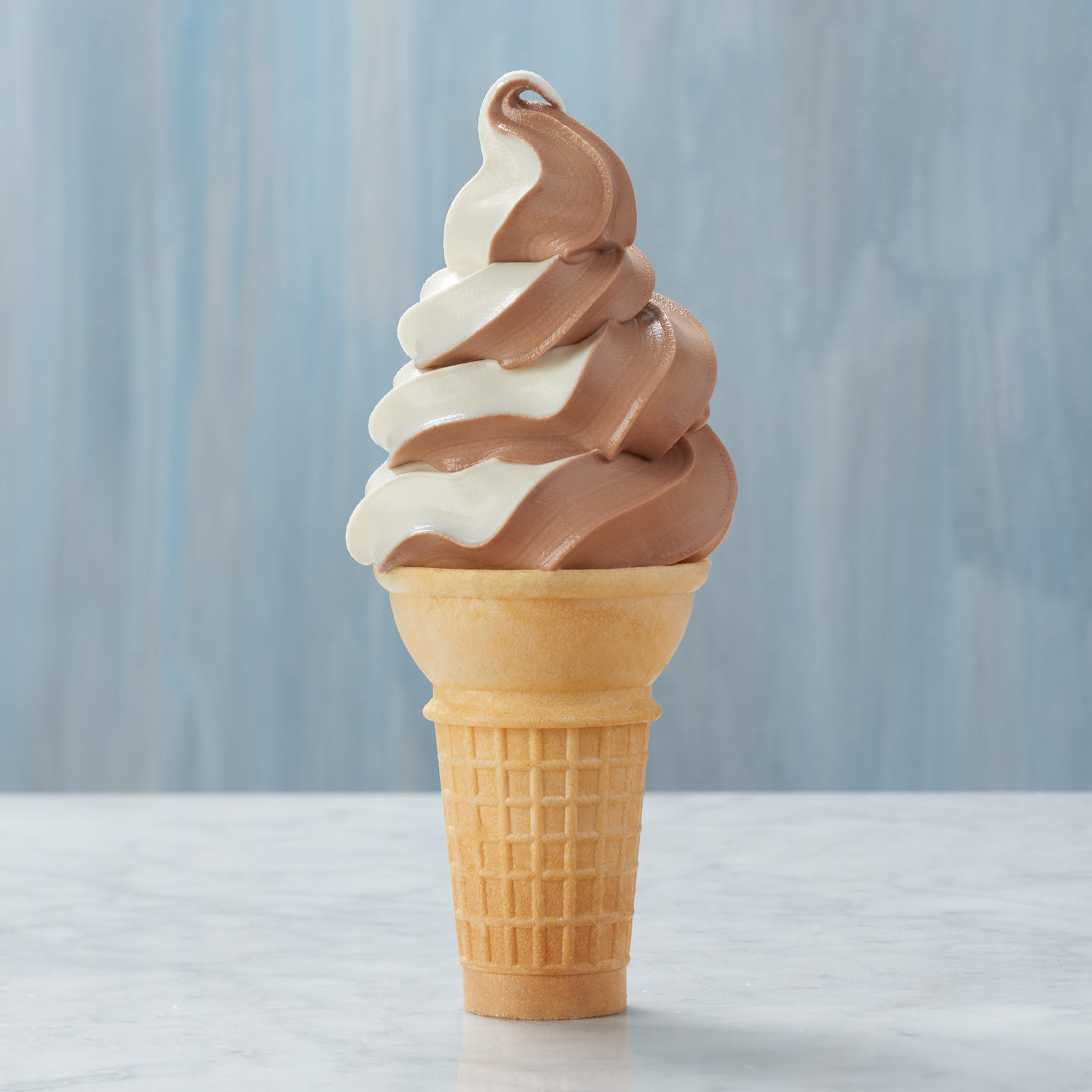 Classic cone filled with chocolate vanilla swirl soft-serve ice cream.