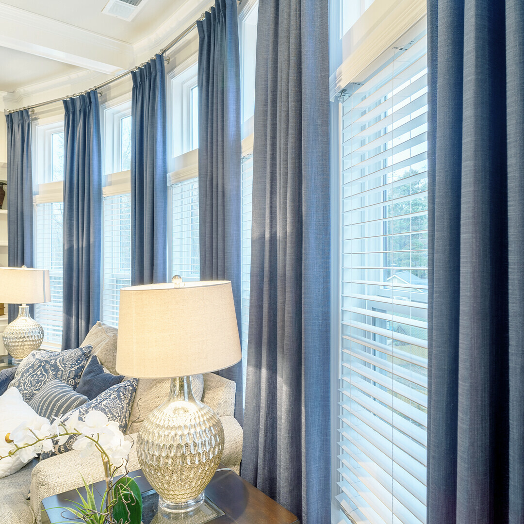 Bring those happy blue sky feelings into your home. This cozy room layers drapery and blinds for both look and function. Layering blinds underneath drapes provides a variety of lighting, privacy, and even insulation benefits.