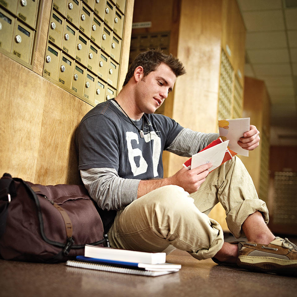 College student reading mail