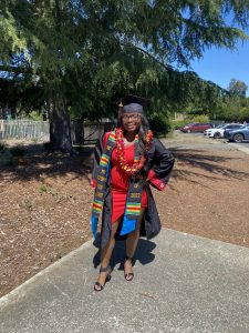 Celena Johnson, in black cap and gown, graduated from California State University East Bay in 2022