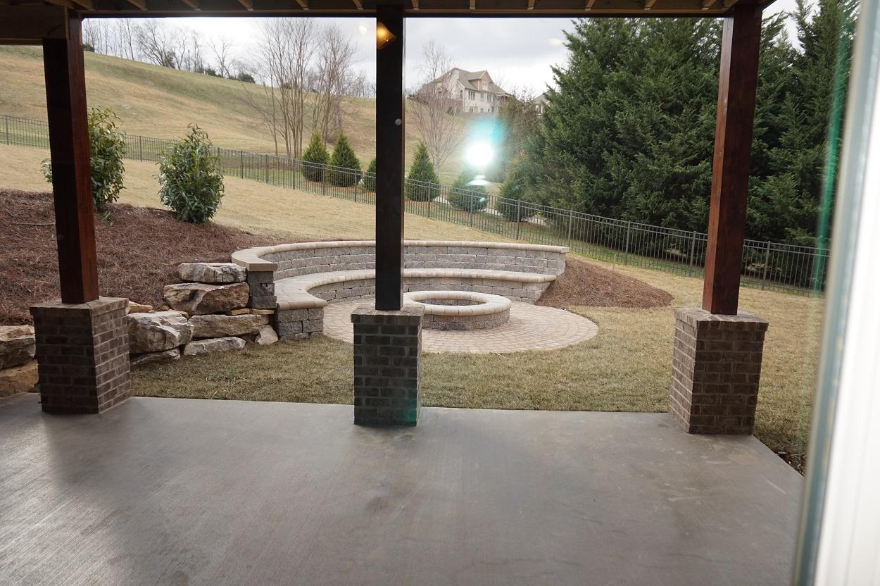 This fire pit was designed with two purposes.  We worked with the natural grade of the property designing a retaining wall that is also a back rest.  From there our seating accommodates owners and guest while entertaining around the fire pit area.  Great job by our landscaper!