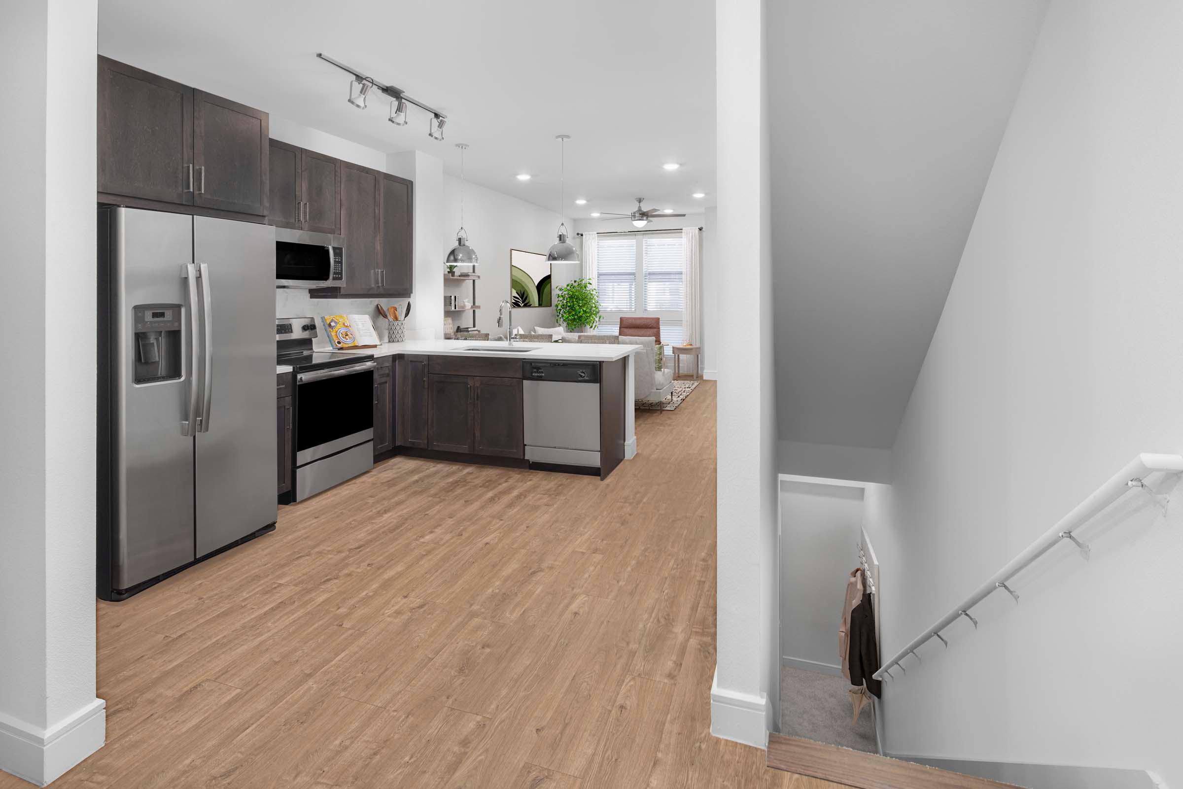 Villas townhome private garage entry stairs leading into the kitchen with brown cabinets at Camden Greenville