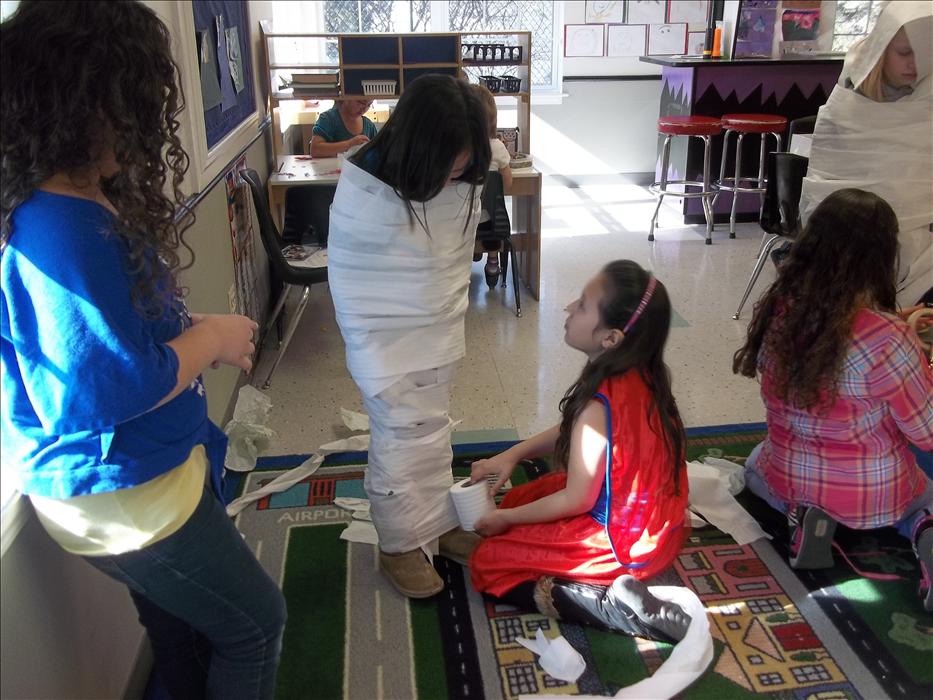Our School Age classroom is learning about Ancient Egypt and this is them preforming a mummy wrap.