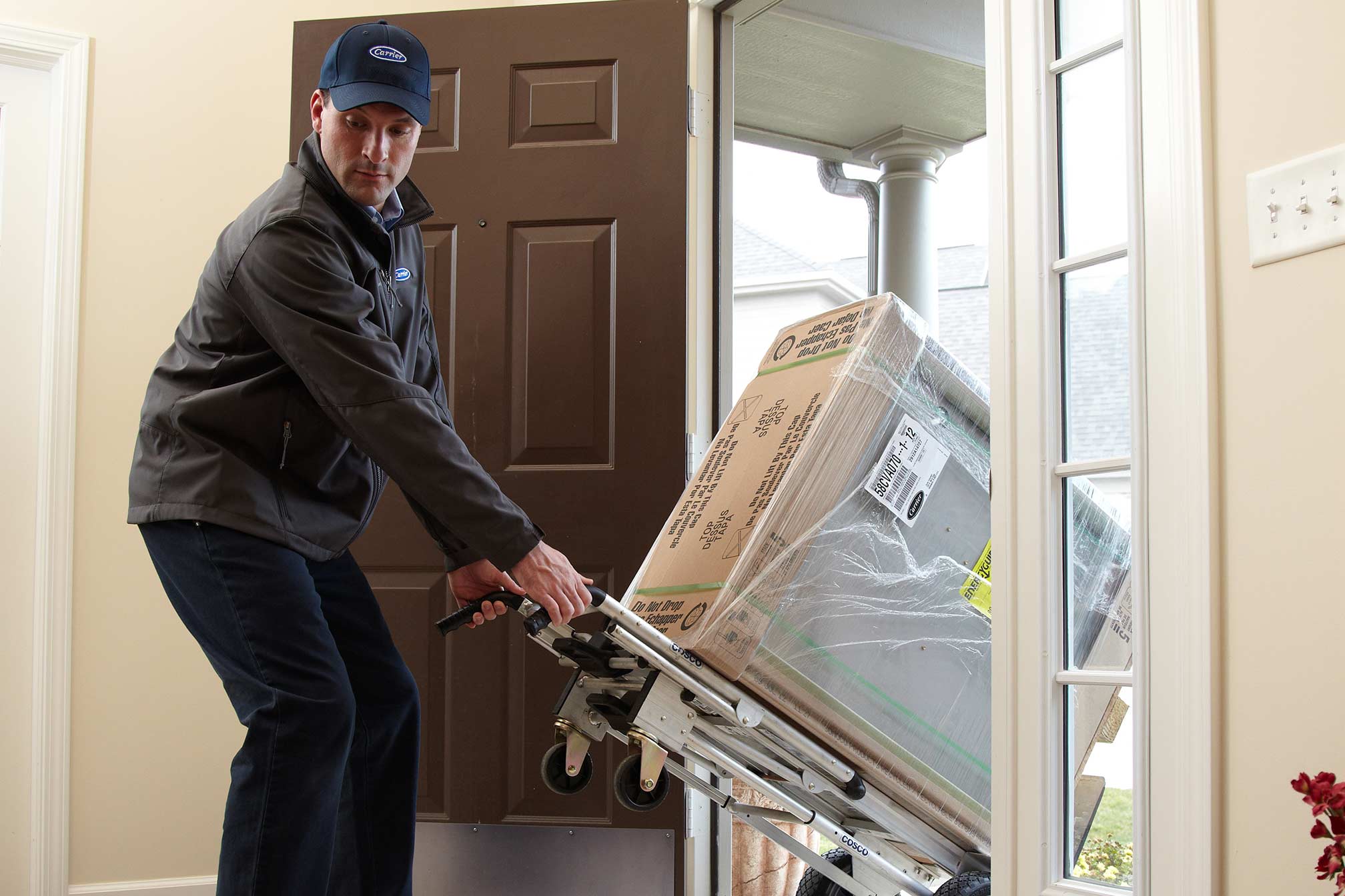 A dealer pulls a furnace on a dolly for an HVAC installation