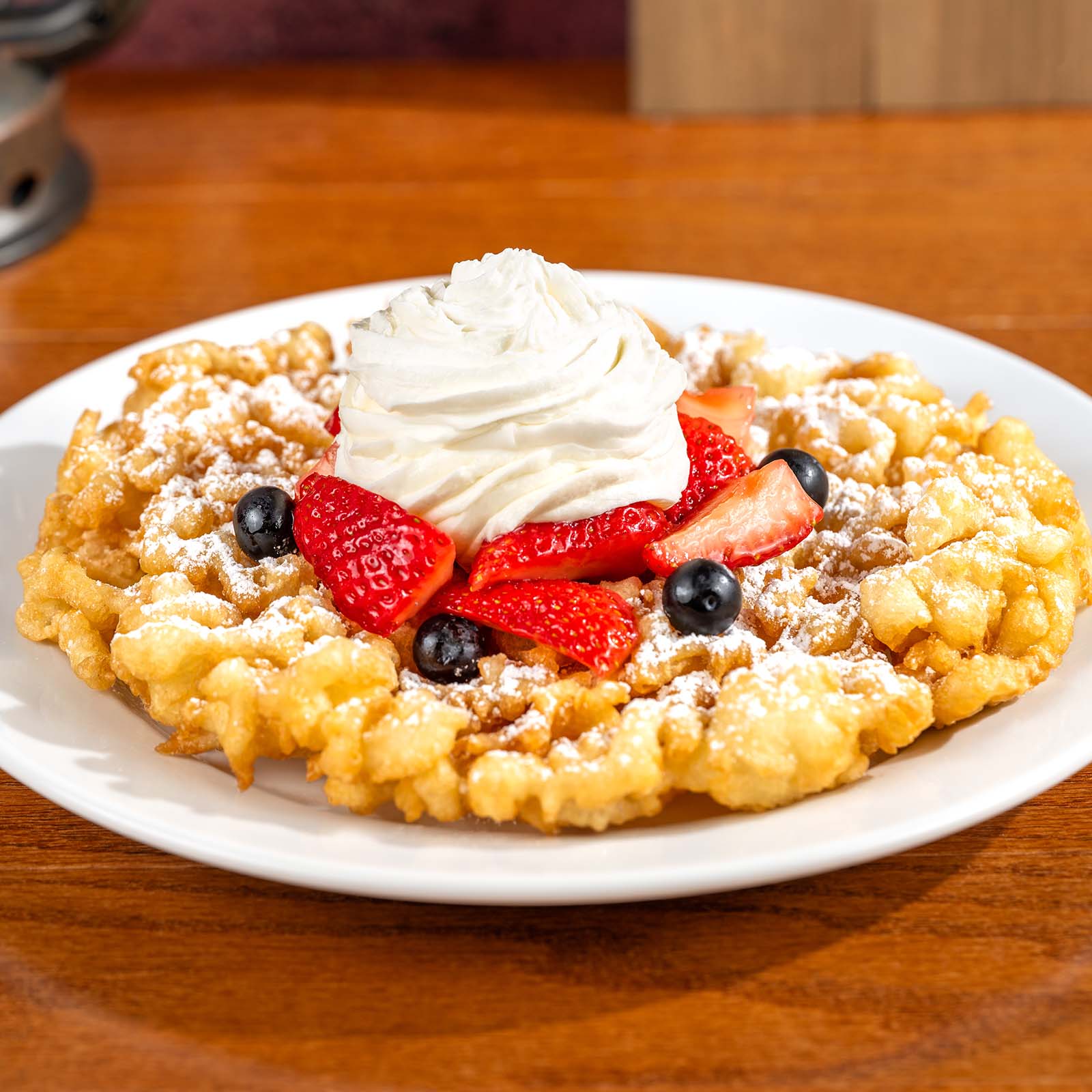 Funnel Cake with Berries, Powdered Sugar, and Whipped Cream