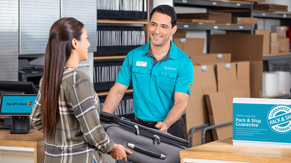 Employee helping customer with luggage shipment