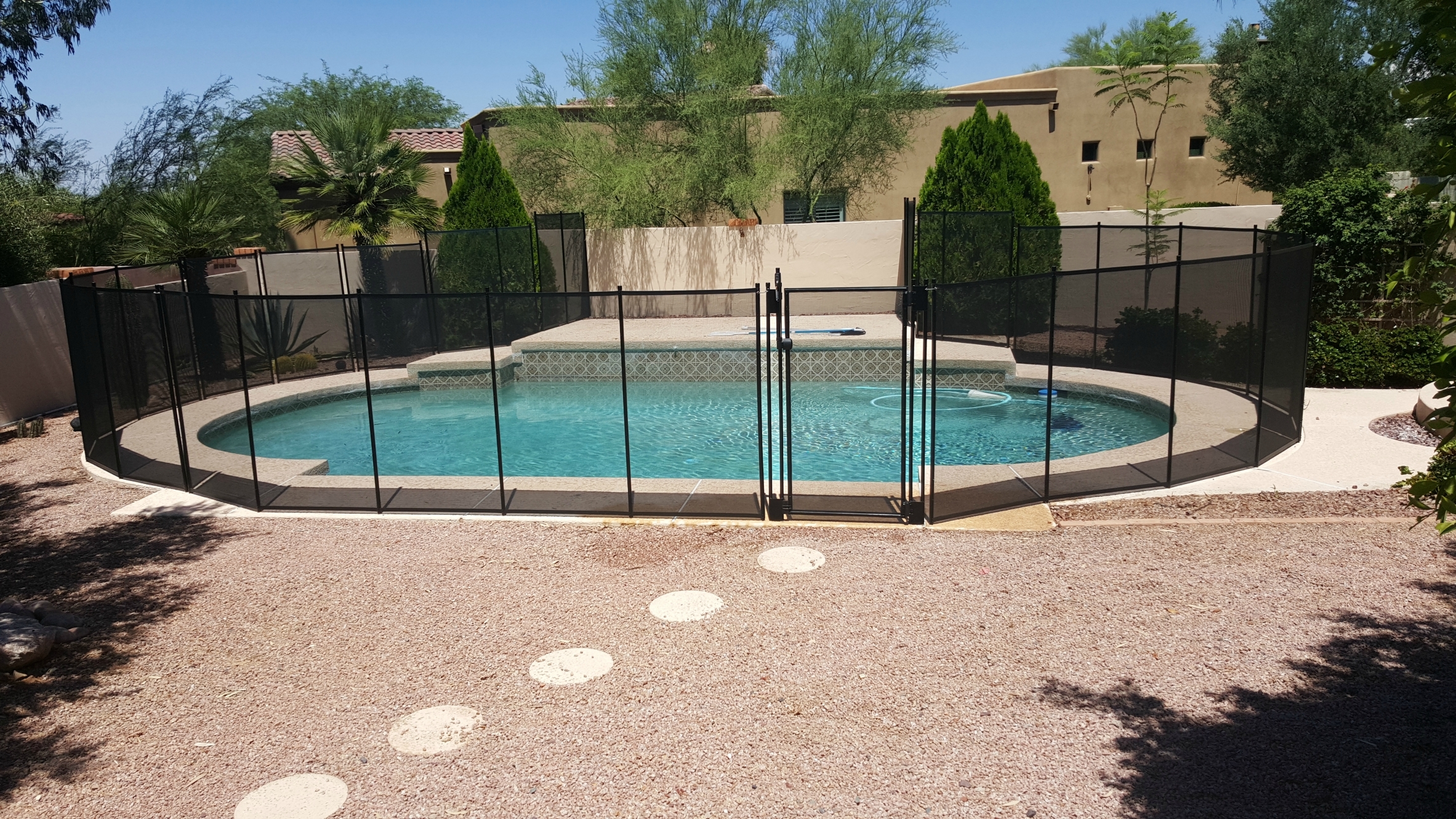 Katchakid removable pool safety fence around a pool with steps.