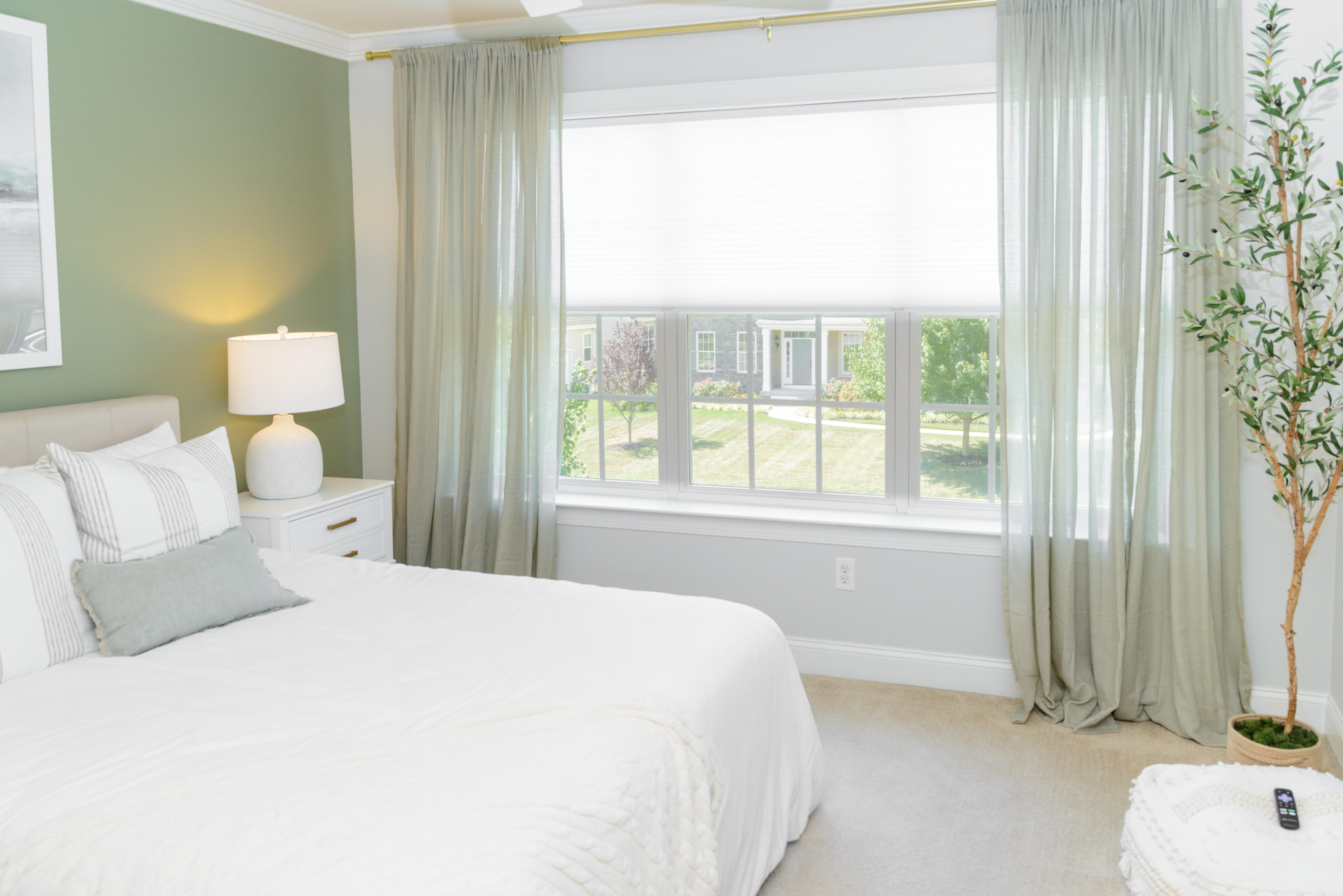 What a combination! Our cellular shades are topped with gorgeous, sage green drapes giving this bedroom a sleek and airy look.