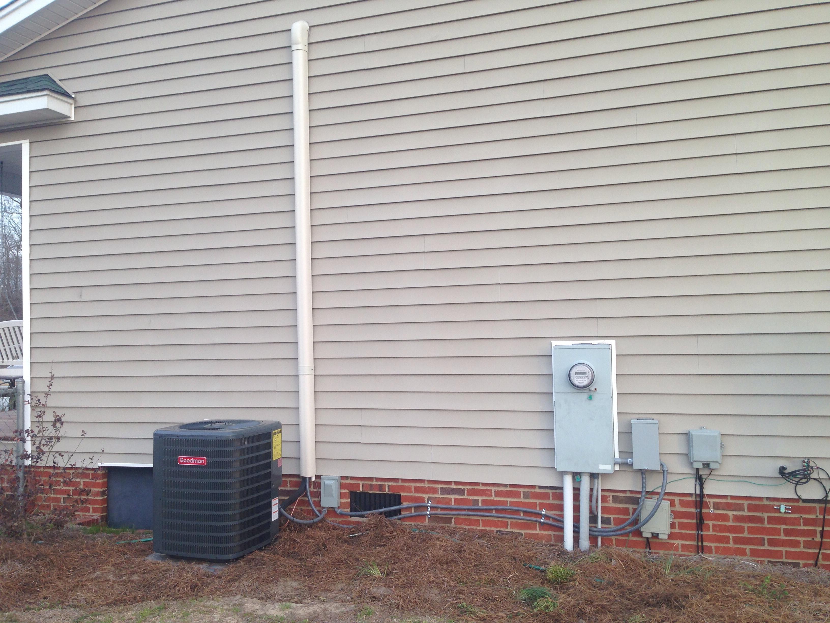 Heat pump install with a wall hide covering refrigerant tubing
