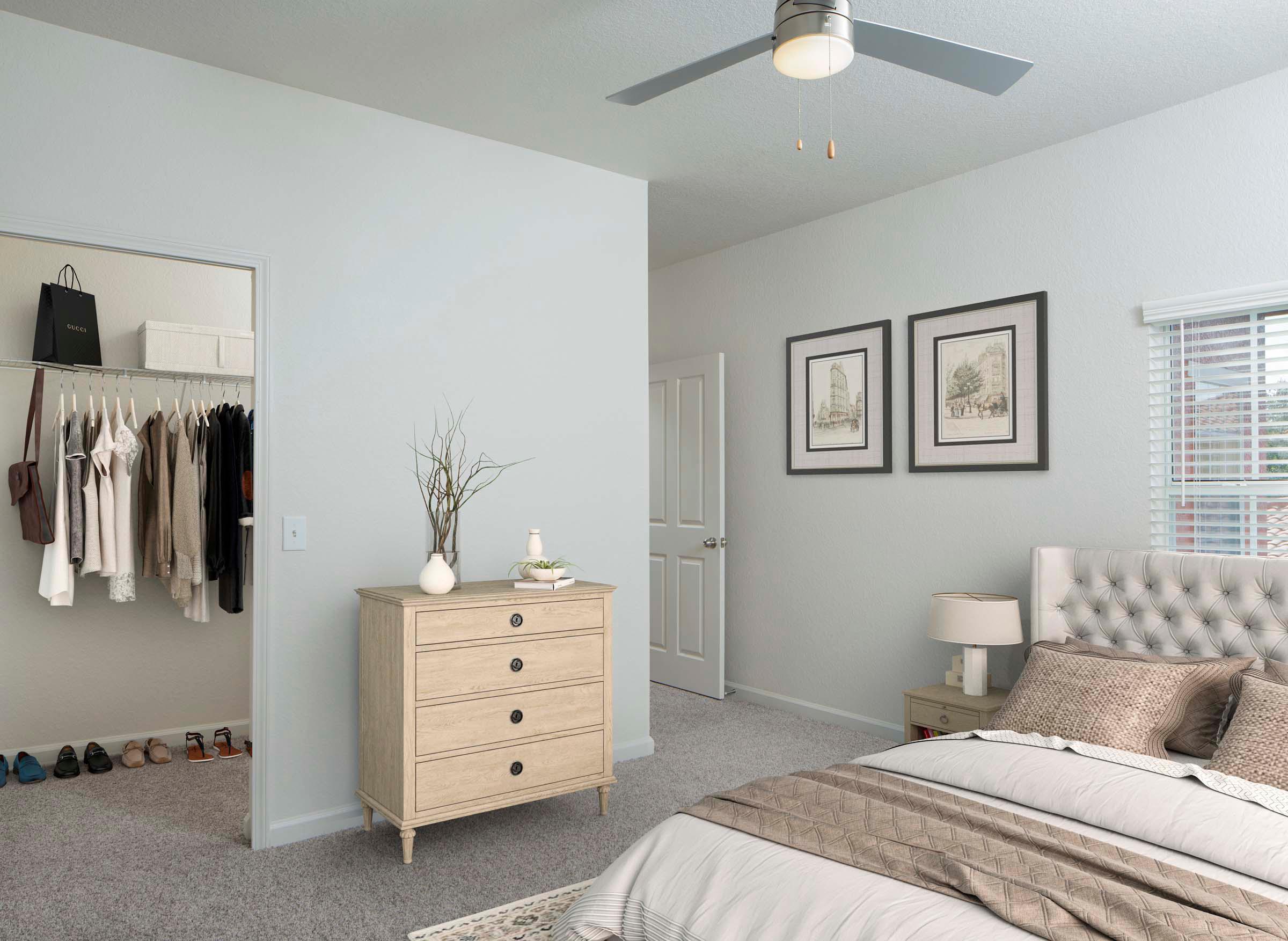 Bedroom with lighted ceiling fan and spacious walk in closet