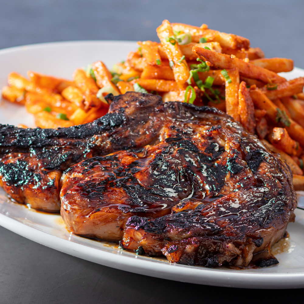 Yard House features a variety of steak dishes, including our 20 oz bone-in ribeye with a sweet soy ginger marinade and chili garlic fries with green onions, parmesan and crispy garlic.