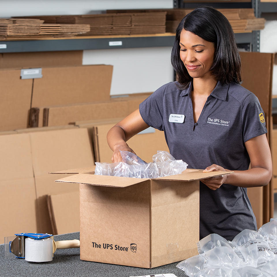 Associate at The UPS Store packing item for shipping