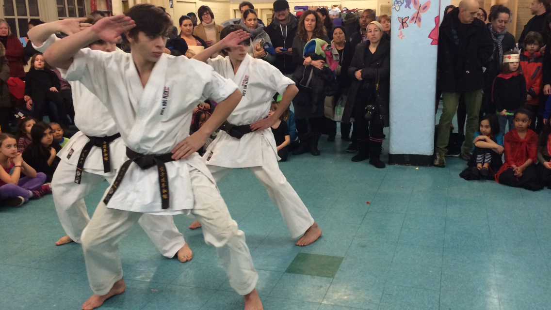 Our Young Sempai demonstrate leadership as they demonstrate a black belt kata for one of our partnering public schools. 